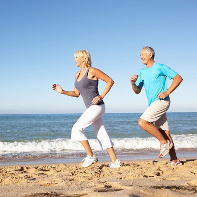 older couple running through park